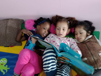 Crianças interagem e aproveitam um aconchegante Cantinho de Leitura